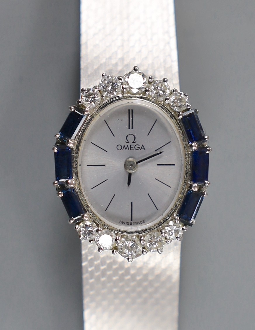 A lady's French 750 white metal Omega manual wind oval wrist watch, with sapphire and diamond set bezel, on integral Omega 750 white metal bracelet, overall 17.7cm, gross weight 52.5 grams, no box or papers.